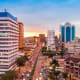 Kampala city skyline at sunset with modern office buildings and bustling downtown street traffic